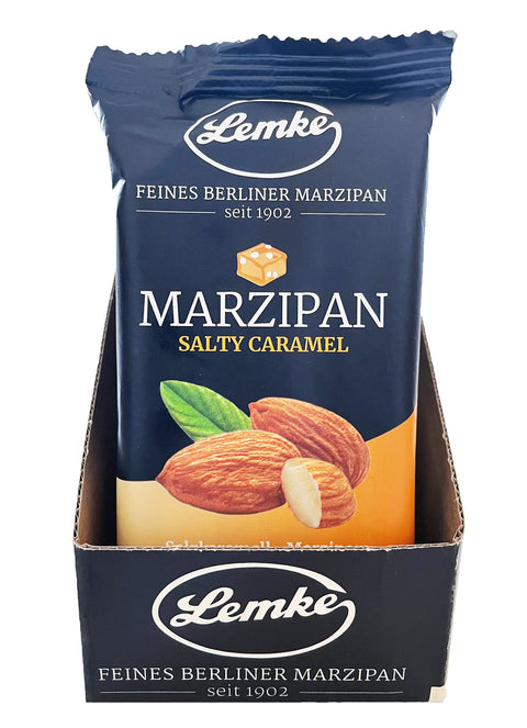 Eine Display-Schale mit 14 Packungen Lemke Salty Caramel Marzipan (je 200g), wobei nur die erste Packung sichtbar ist. Die Verpackung ist Ÿberwiegend schwarz mit dem Lemke-Logo, dem Schriftzug "Feines Berliner Marzipan seit 1902" und einem Bild von Mandeln und Salzkaramell.
