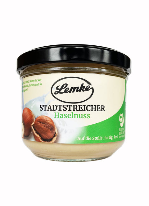 Ein Glas Lemke Stadtstreicher Haselnusscreme. Perfekt als cremiger Aufstrich für Brot, Waffeln oder zum Verfeinern von Joghurt und Desserts.
